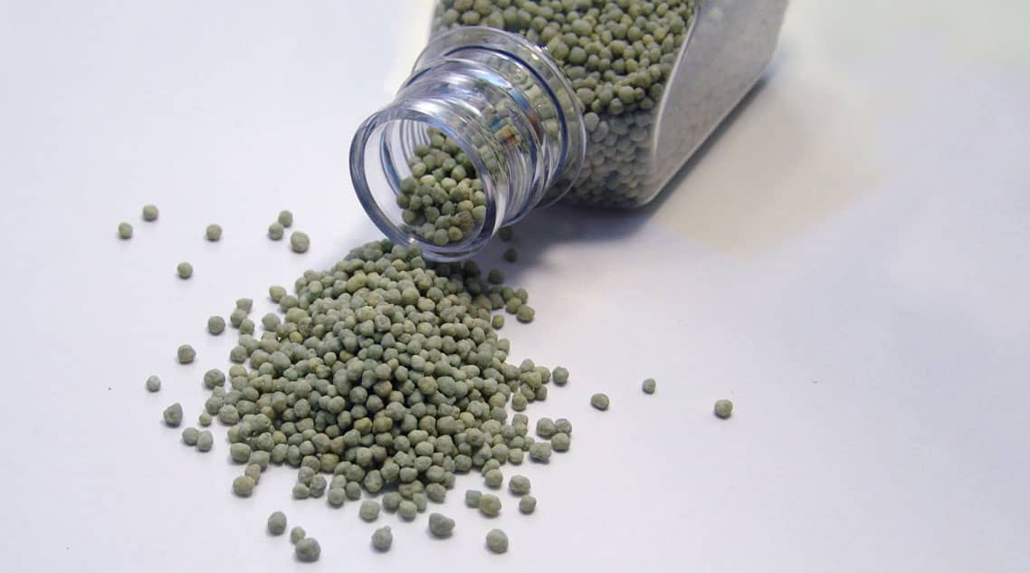 Fertilizer pellets spilling from a bottle