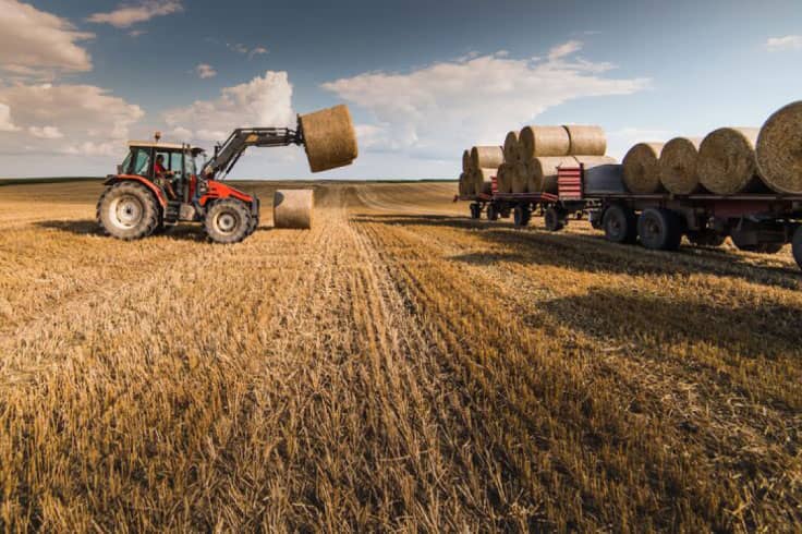 Tractor forking a hay bale