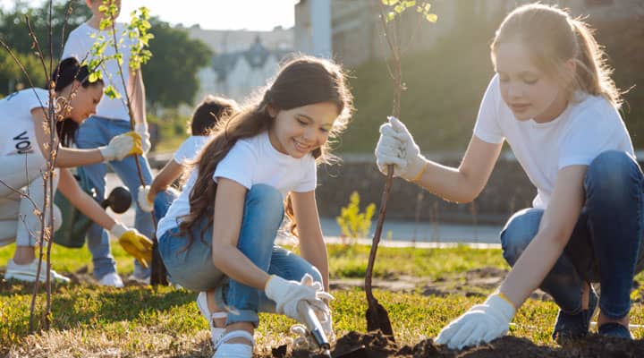 two young girls planting trees