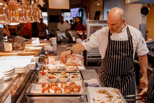 Man in apron looking at food line